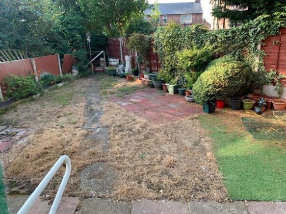 A spacious garden area with a mix of grass and ...
