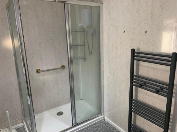 A modern bathroom suite featuring a walk-in sho...