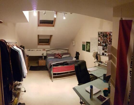 Bright and cozy master bedroom with skylight wi...
