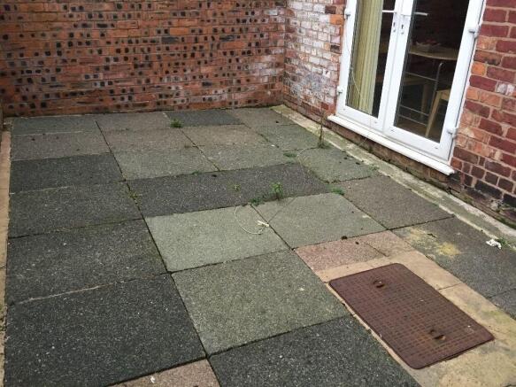 A modest private outdoor garden area with paved...