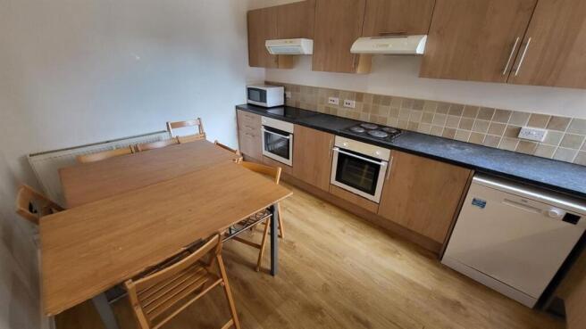 A modern kitchen featuring wooden cabinetry, bu...