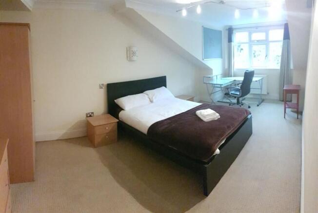 Well-lit double bedroom featuring a comfortable...