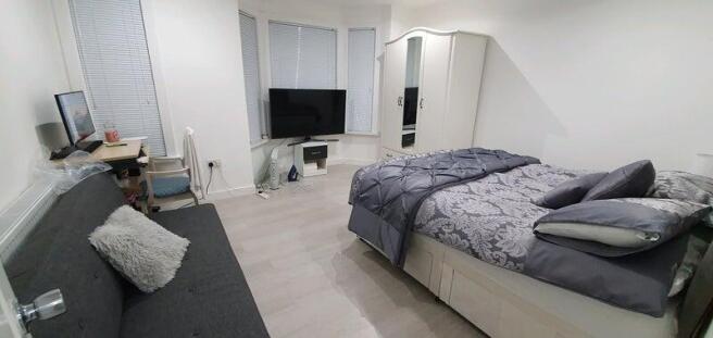 A spacious and neatly arranged master bedroom f...