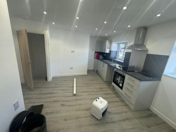 Modern kitchen featuring sleek cabinetry, built...