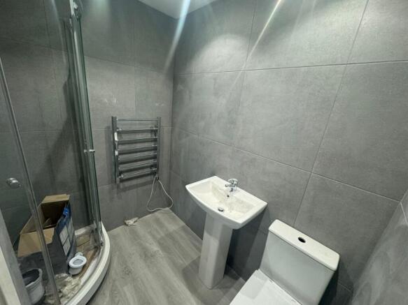 A modern bathroom featuring sleek grey tiles, a...