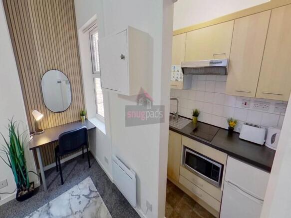 Compact and clean kitchen with modern light woo...