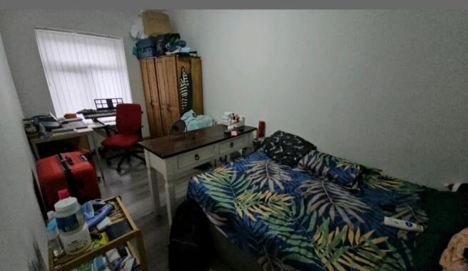 A cozy double bedroom featuring a vibrant tropi...