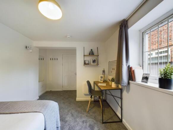 A spacious and tidy double bedroom featuring a ...