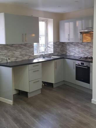 Modern kitchen with ample natural light, featur...