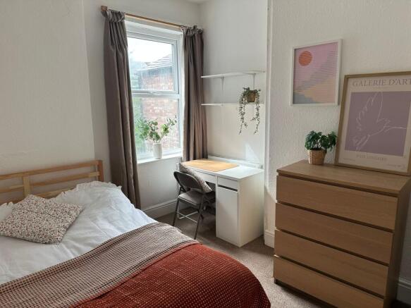 A cozy bedroom featuring a single bed with flor...