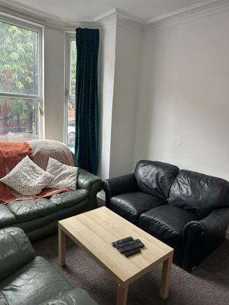 A cozy living room featuring two leather sofas,...