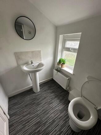 Bright and clean bathroom featuring a white ped...