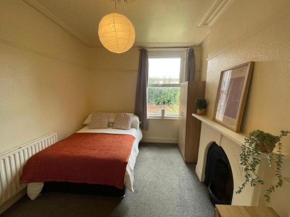 A cozy and well-maintained bedroom featuring a ...