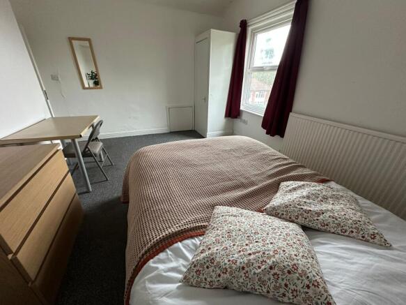 A cozy single bedroom featuring a comfortable b...