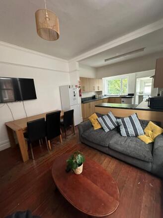 A spacious, well-lit living room featuring a co...