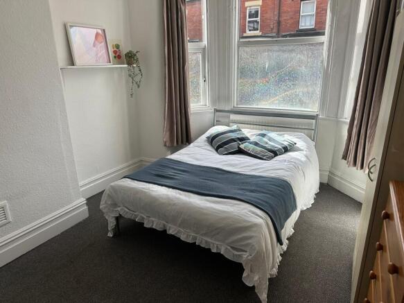 Bright and cozy bedroom with ample natural ligh...