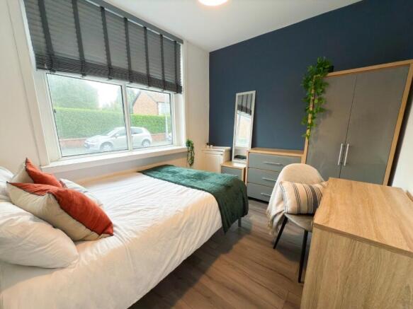 A bright and welcoming bedroom featuring a neat...