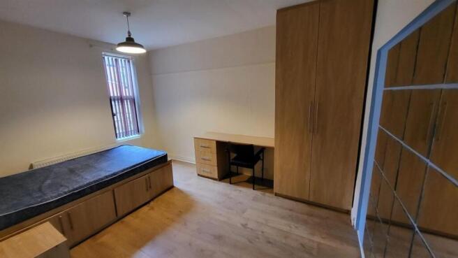 A bright and well-maintained bedroom featuring ...