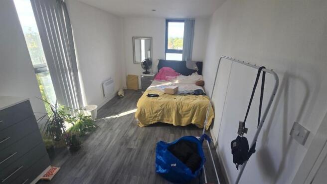 A cozy and well-lit bedroom with a bed, window ...