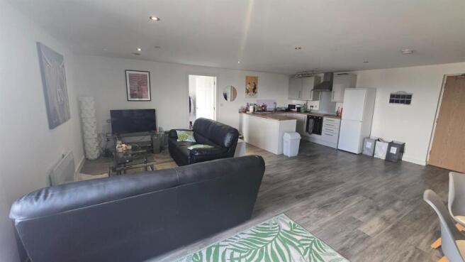 Spacious and well-lit living room featuring com...