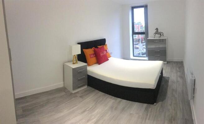 A stylish and spacious master bedroom featuring...