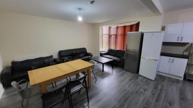 A well-lit, spacious living room featuring comf...