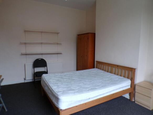 Bright, simply furnished bedroom with a wooden ...
