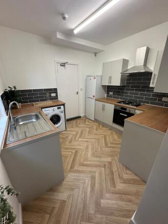Modern kitchen with wooden countertops, white c...