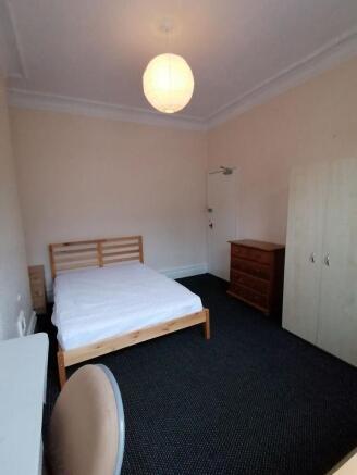 Bright, simply furnished double bedroom with a ...