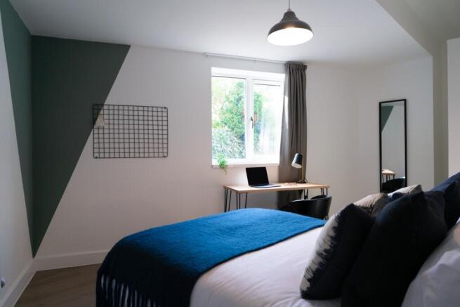 A stylish and bright double bedroom featuring a...