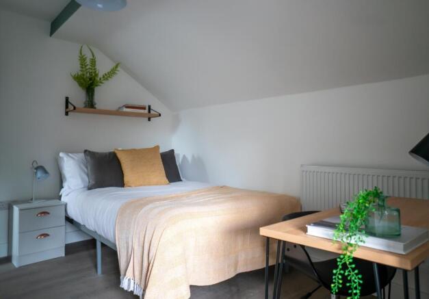 A bright and inviting double bedroom featuring ...