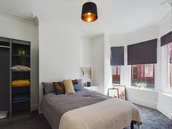 A bright and inviting double bedroom with styli...
