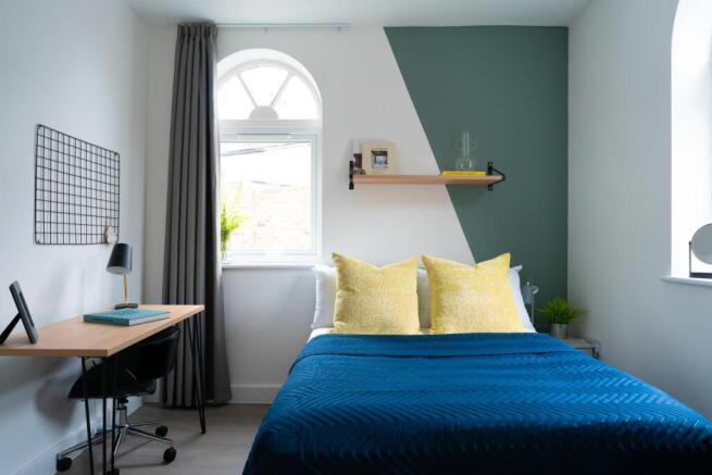 A bright and inviting bedroom featuring a comfo...