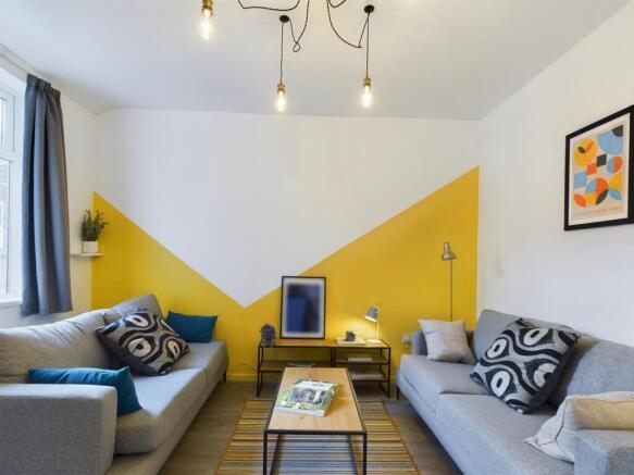 This vibrant living room features stylish grey ...