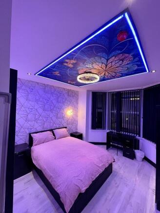 A stylish master bedroom featuring a comfortabl...