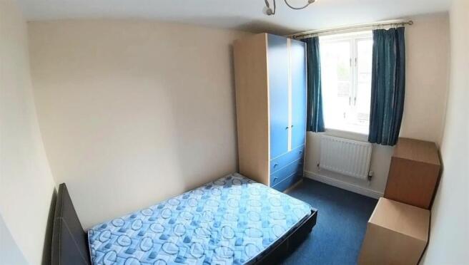 A cozy student bedroom featuring a single bed a...