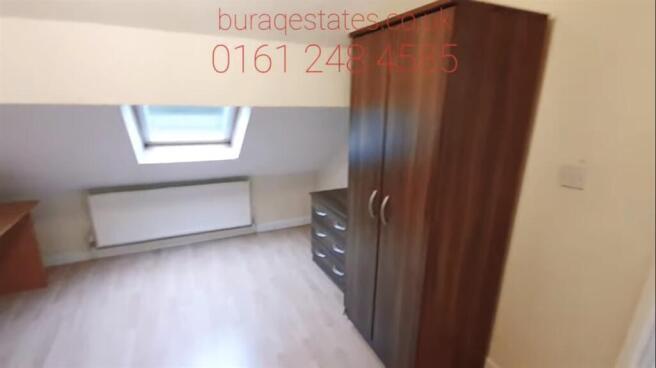 A bright and tidy bedroom featuring a wardrobe,...