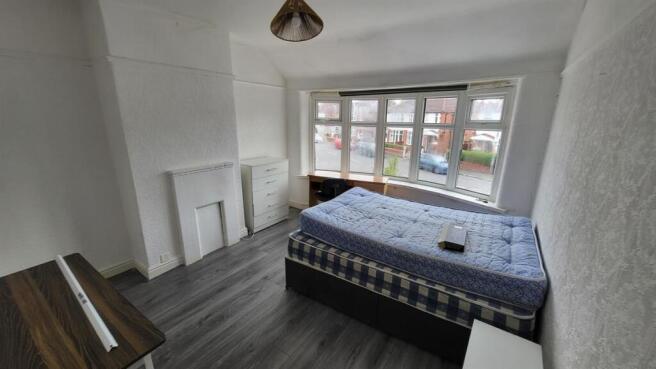 Spacious master bedroom with a large window pro...