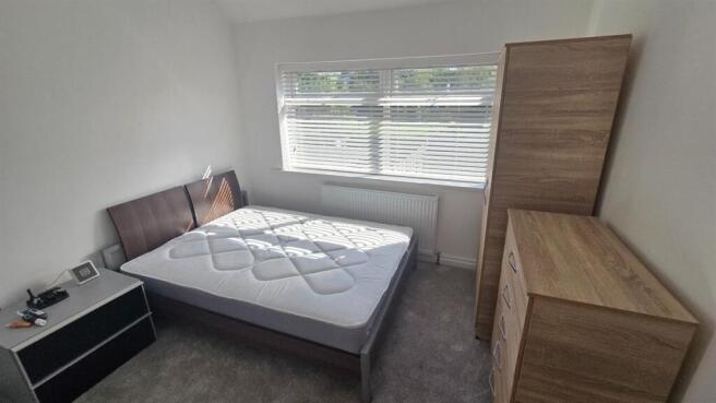 A well-lit, neatly maintained double bedroom wi...