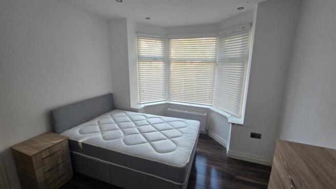 A bright and tidy bedroom featuring a comfortab...