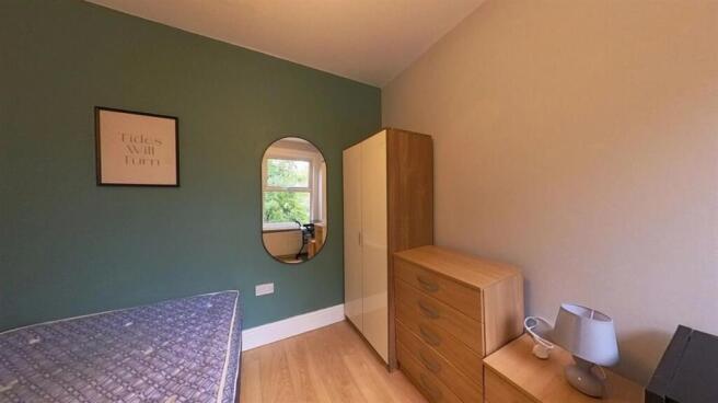 A cozy bedroom featuring a single bed with colo...