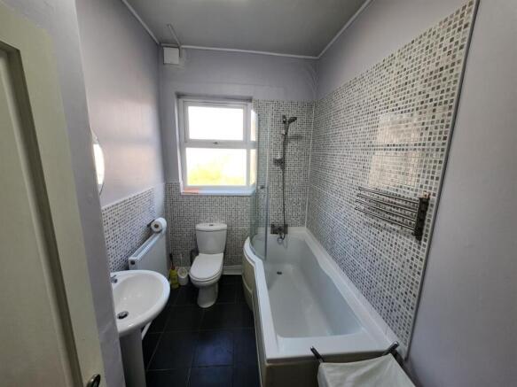 A modern bathroom with a large bathtub, a windo...