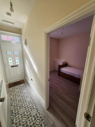 A cozy bedroom with soft pink walls, featuring ...