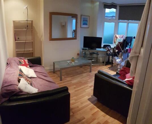 A spacious and well-lit living room featuring c...