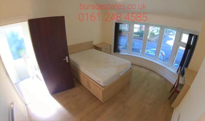 A bright and inviting double bedroom with a lar...