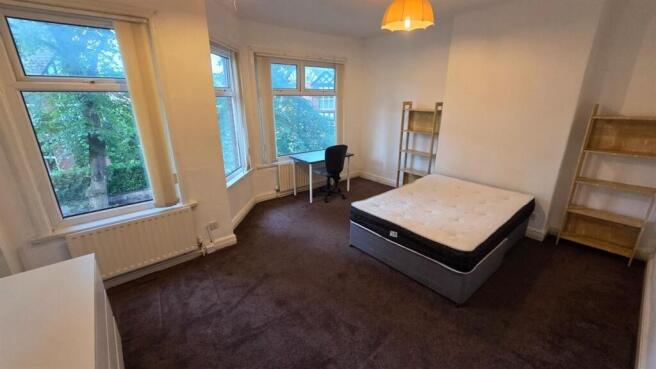 Bright double bedroom with a large bay window o...
