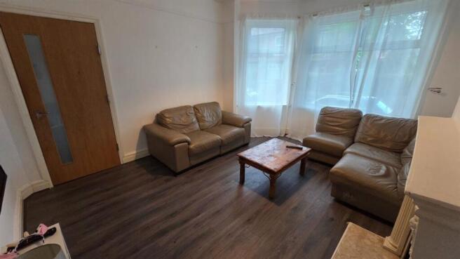 Bright, simply furnished living room with large...