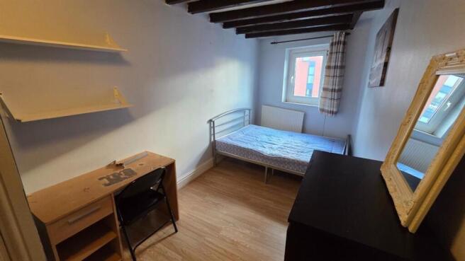 A cozy single bedroom featuring a bed positione...