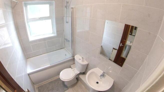 A clean and modern bathroom featuring a bathtub...
