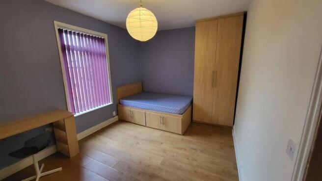 A well-lit double bedroom featuring a single be...